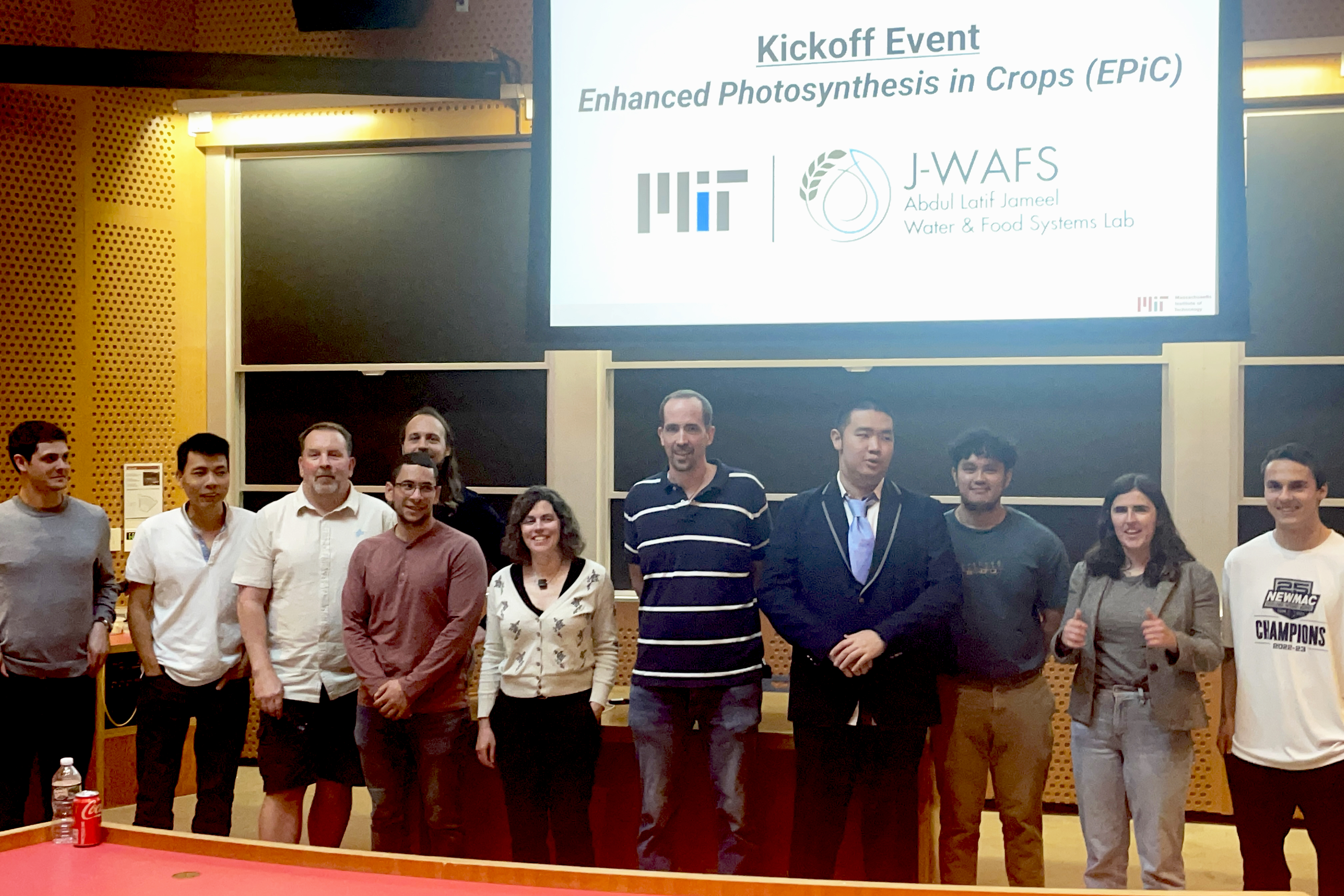 A group of 11 people standing in a lecture hall in front of a presentation screen that says Kick off Event Enhanced Photosynthesis in Crops (EPiC)  