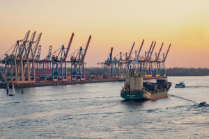 Photo of large boat on the water with dock behind it during a sunset