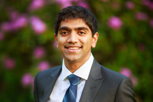 A headshot of Vishnu Jayaprakash who is posed in front of greenery.