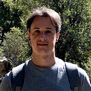 César Terrer standing outside in a gray shirt and backpack