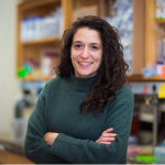 Tami Lieberman with arms folded in front of chest standing in her lab