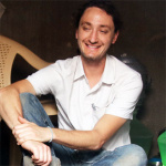 Brown haired man sitting cross legged on the floor