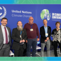 Five people standing in front of the UN Climate Change Conference banner